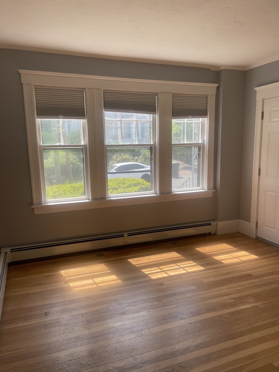 21 Arbor Lane, Unit 21 Dedham, MA 02026 - Photo 9 of 10 a view of an empty room with wooden floor and a window