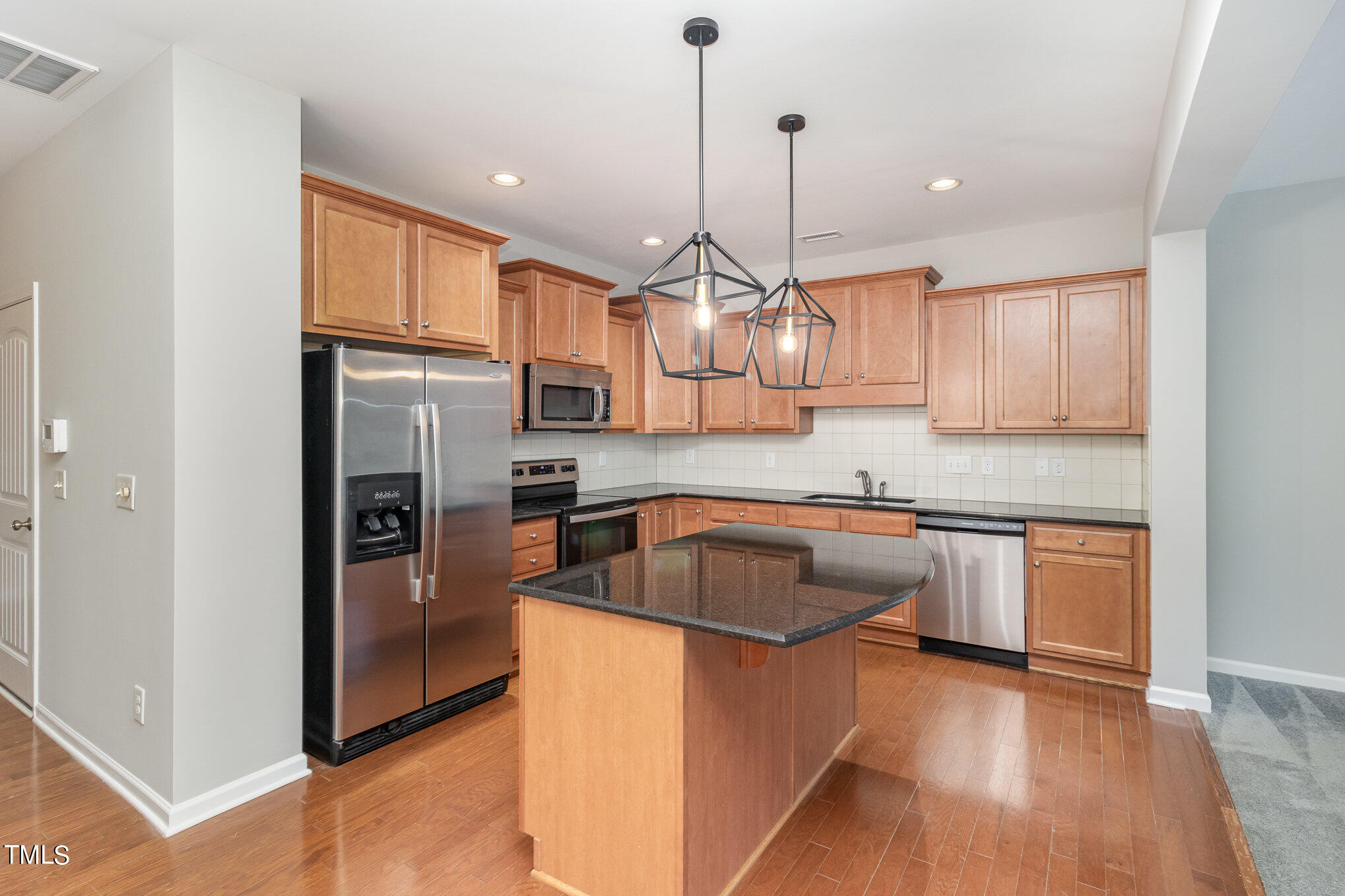 2418 Memory Ridge Drive Raleigh, NC 27606 - Photo 7 of 27 a kitchen with stainless steel appliances granite countertop a sink a stove a refrigerator cabinets and wooden floor