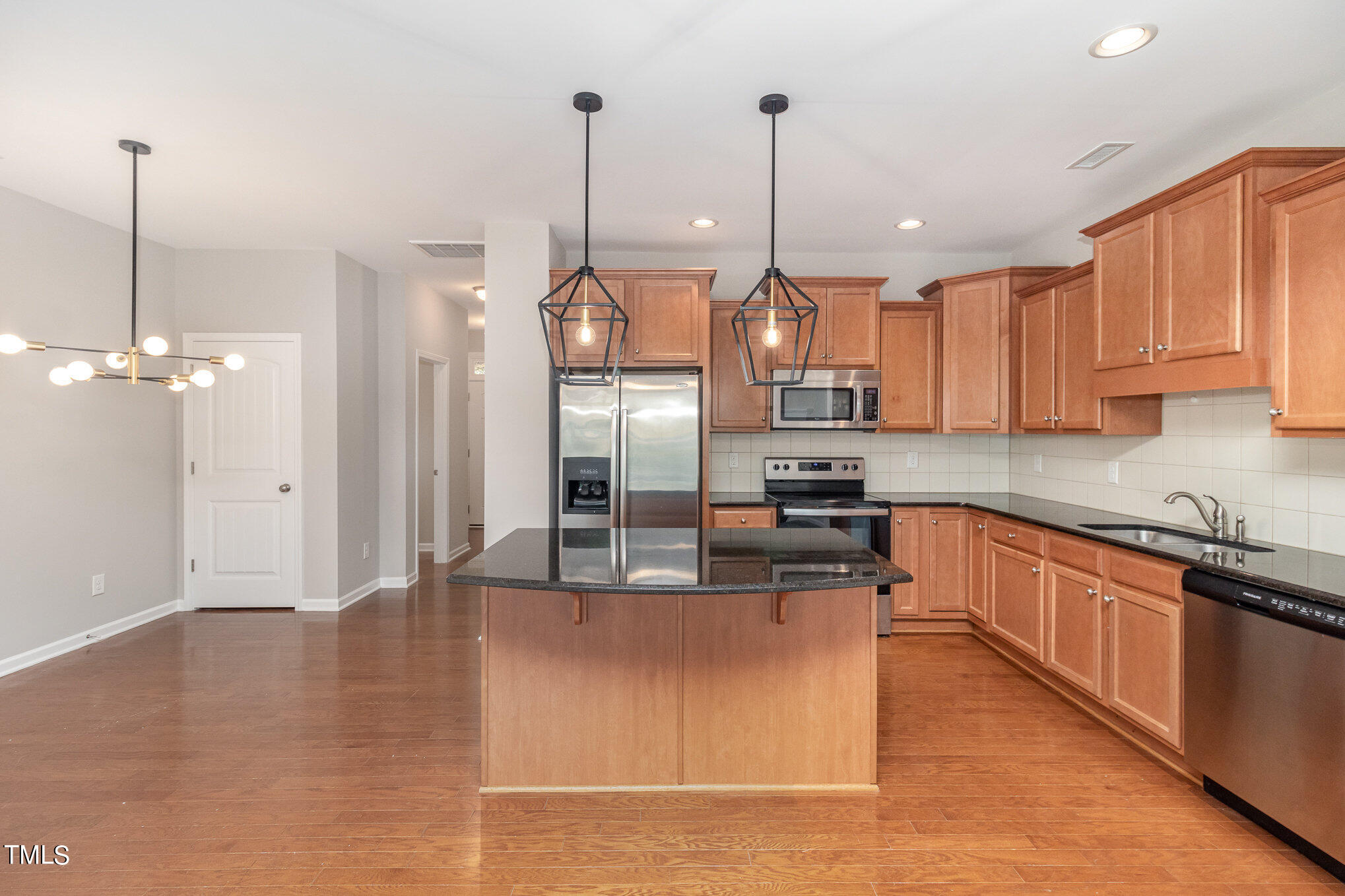 2418 Memory Ridge Drive Raleigh, NC 27606 - Photo 8 of 27 a kitchen with stainless steel appliances granite countertop a refrigerator a sink and a wooden floors