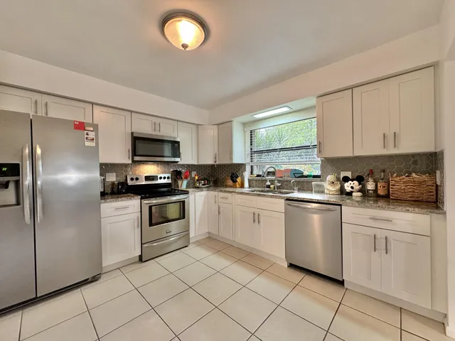 a kitchen with white cabinets stainless steel appliances and sink