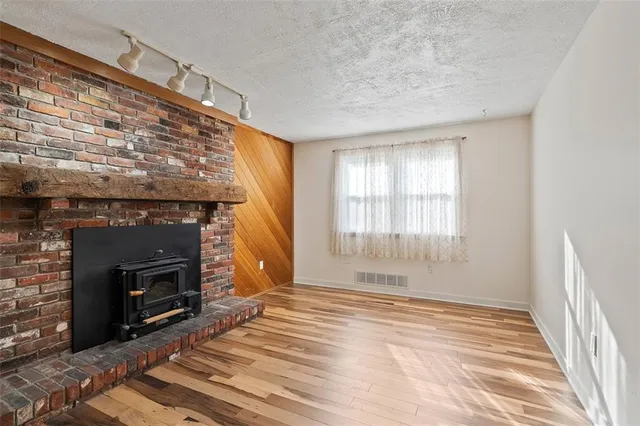 a view of an empty room with a fireplace and a window