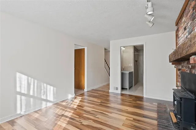a view of a hallway with wooden floor and staircase
