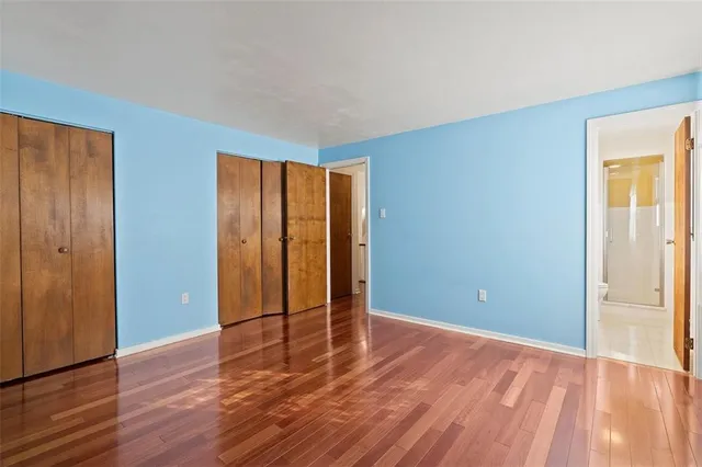an empty room with wooden floor and closet