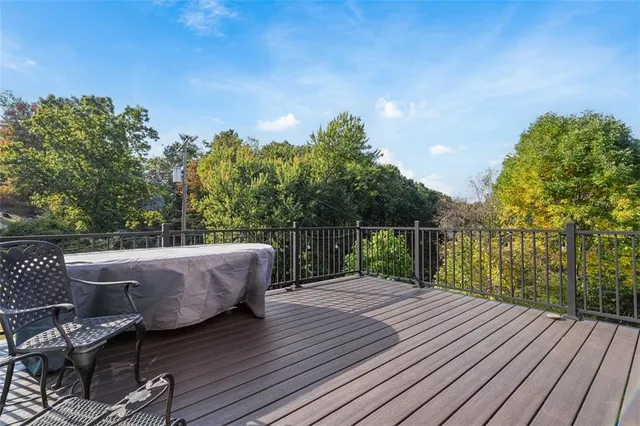 a balcony with wooden floor table and chairs