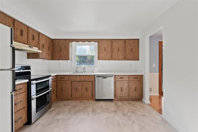 a kitchen with granite countertop a stove top oven sink and cabinets