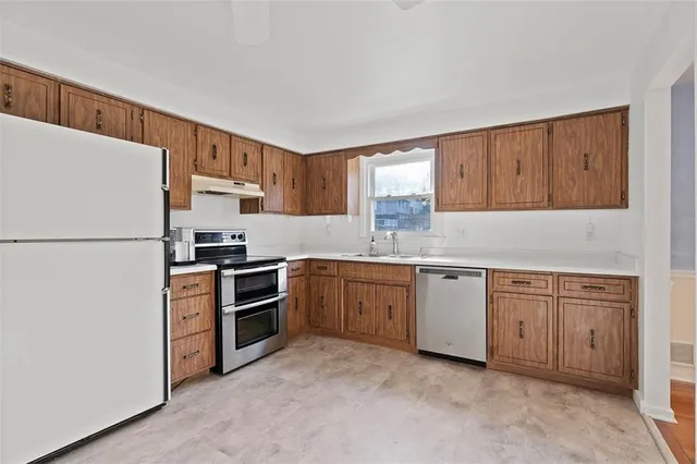 a kitchen with stainless steel appliances granite countertop a refrigerator and a stove top oven