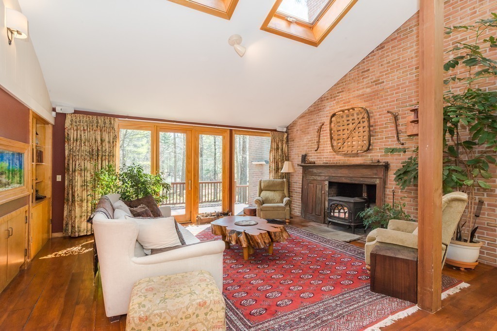 412 Linebrook Road Ipswich, MA 01938 - Photo 8 of 30 a living room with furniture a rug a fireplace and a floor to ceiling window