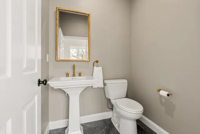 a bathroom with a toilet sink and mirror