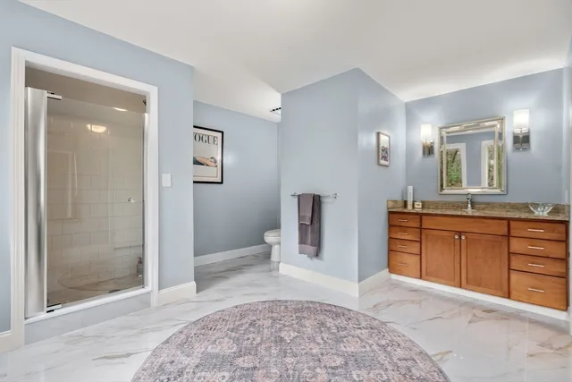 a spacious bathroom with a granite countertop sink mirror and shower