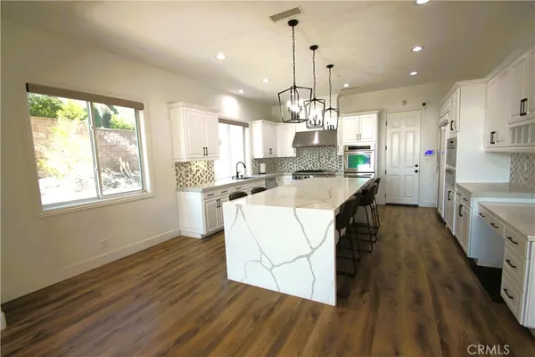 a kitchen with stainless steel appliances granite countertop a sink a stove and a refrigerator