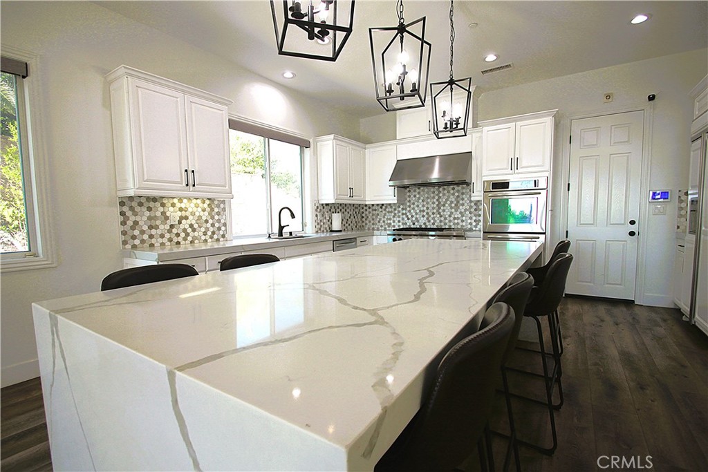 5016 Corral Court Rancho Cucamonga, CA 91737 - Photo 18 of 70 a kitchen with stainless steel appliances granite countertop a sink a stove and a refrigerator