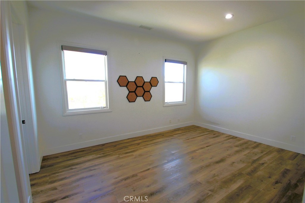 5016 Corral Court Rancho Cucamonga, CA 91737 - Photo 31 of 70 an empty room with wooden floor and windows