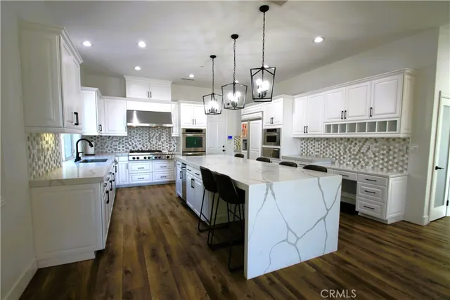 a large kitchen with stainless steel appliances granite countertop a stove a sink and a refrigerator