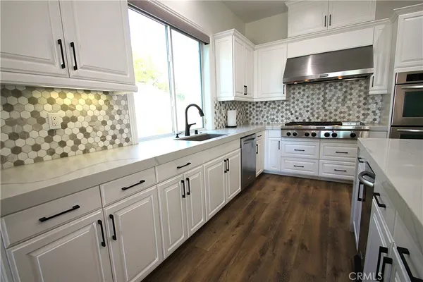a kitchen with granite countertop a stove and a shower