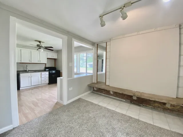 a view of an empty room with cabinet and stairs