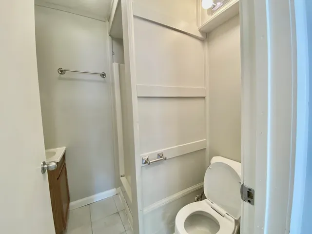 a white toilet sitting next to a shower