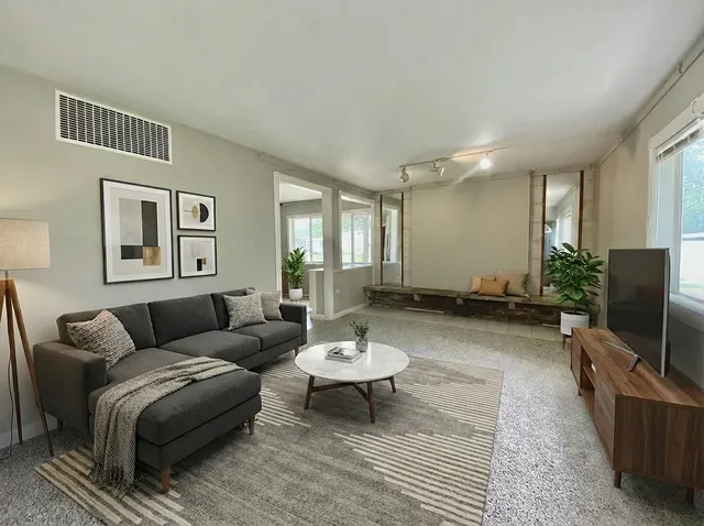 a living room with furniture a window and a flat screen tv