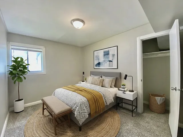 a bedroom with a bed and a potted plant