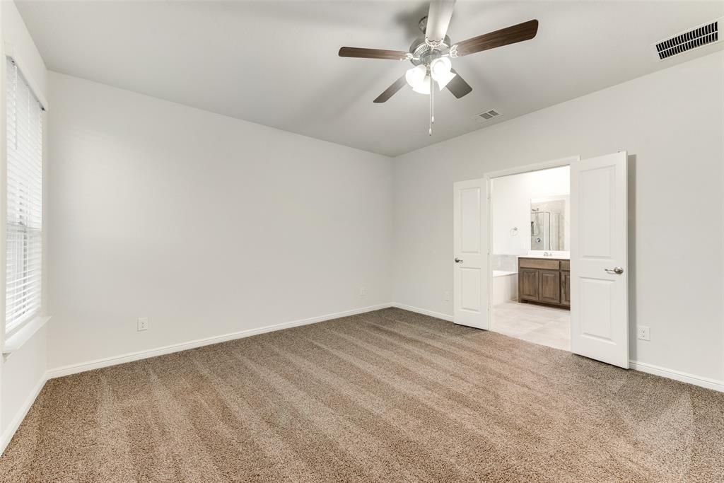 1419 Fox Hollow Road Krum, TX 76249 - Photo 20 of 29 Unfurnished bedroom featuring light colored carpet, ceiling fan, and connected bathroom
