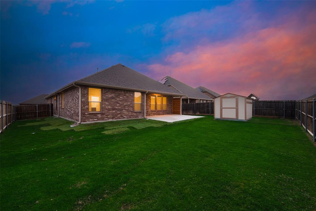 1419 Fox Hollow Road Krum, TX 76249 - Photo 26 of 29 Back of property with a fenced backyard, a patio, a shed, brick siding, and roof with shingles