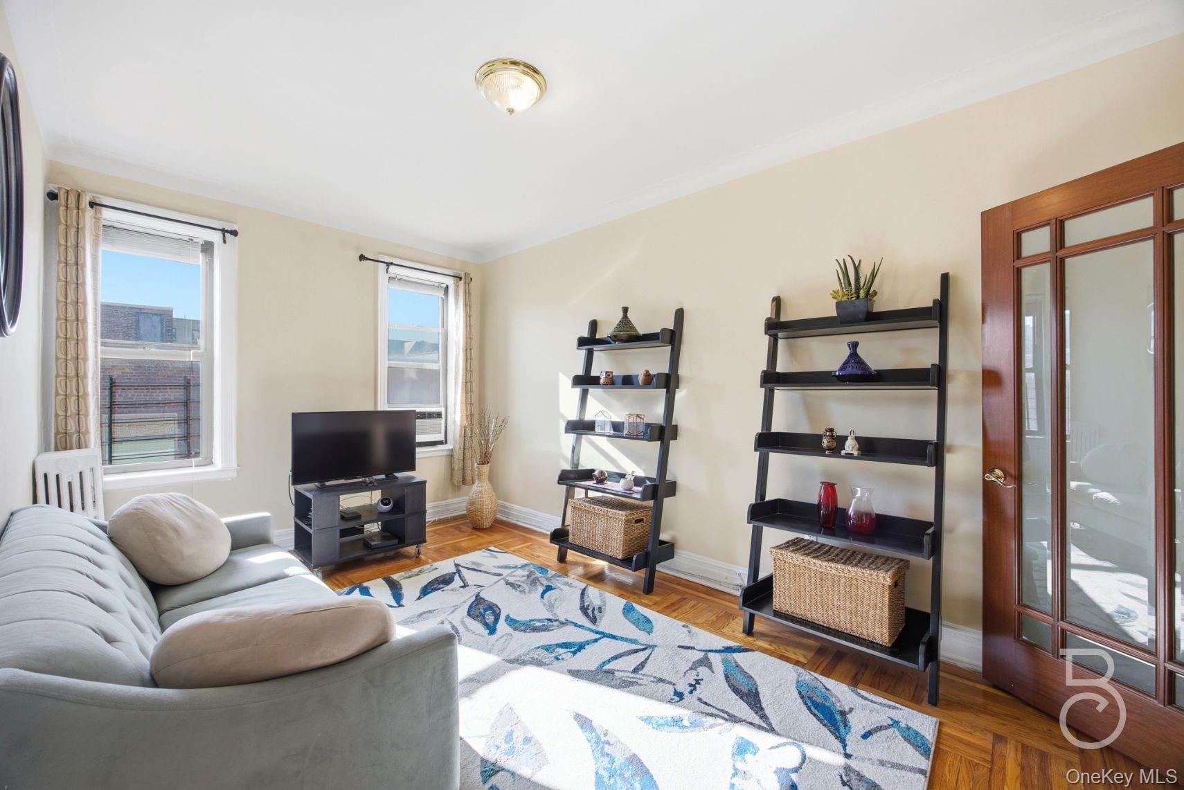 a living room with furniture a flat screen tv and a bookshelf