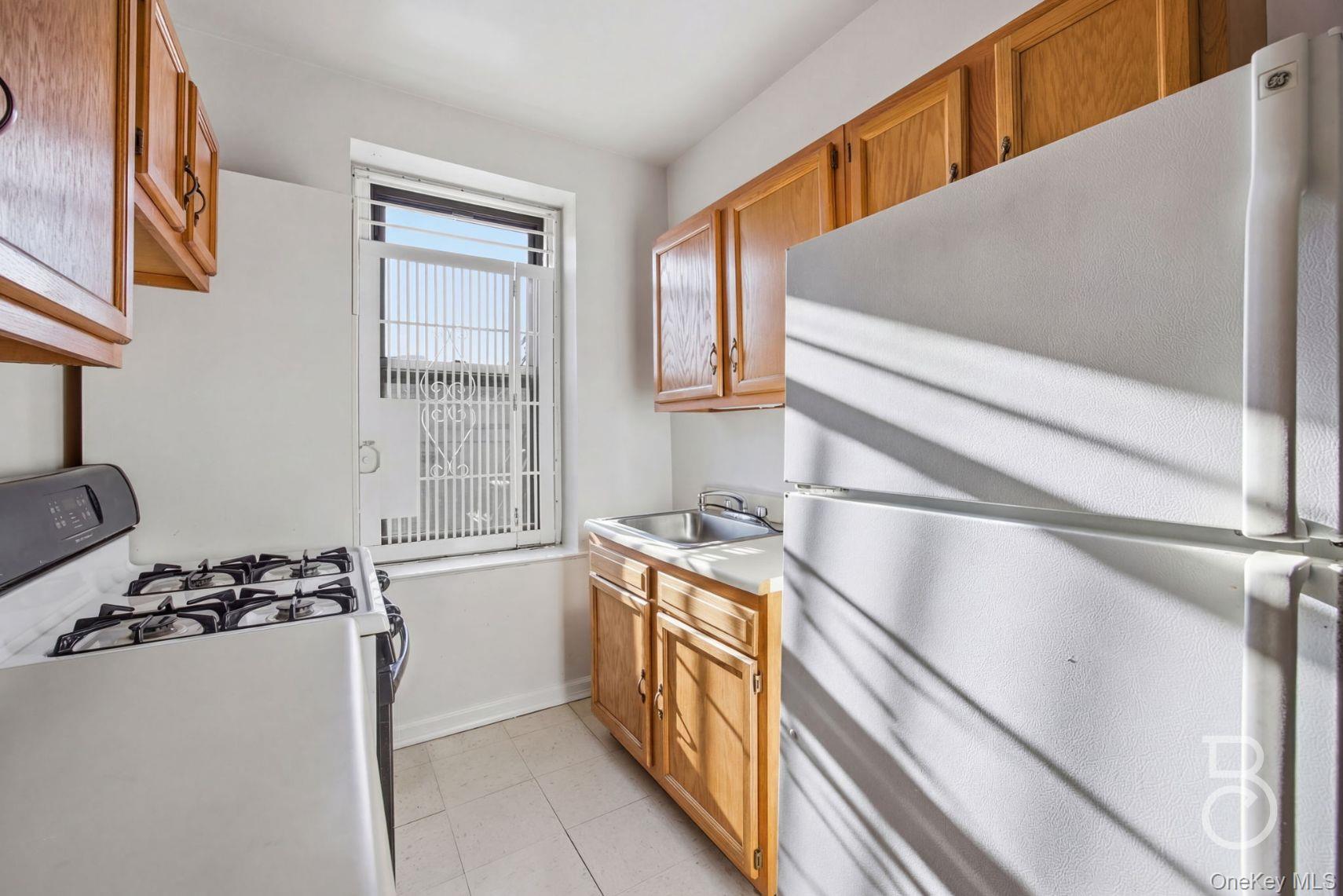 37-16 83rd Street, Unit 3F Queens, NY 11372 - Photo 7 of 11 a kitchen with a stove a refrigerator and cabinets