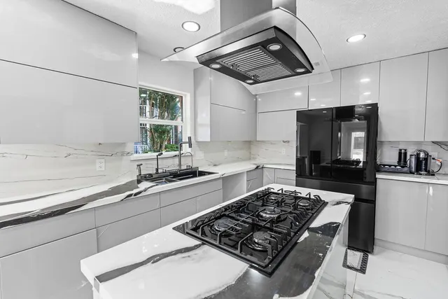 a kitchen with stainless steel appliances a sink stove and refrigerator