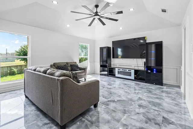 a living room with furniture a ceiling fan and a rug