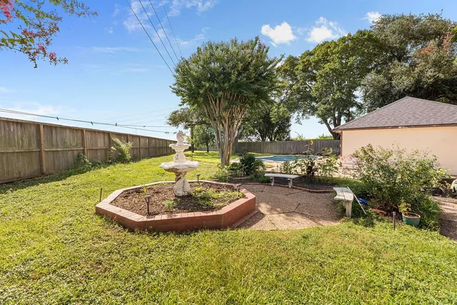 a view of a house with a yard and potted plants