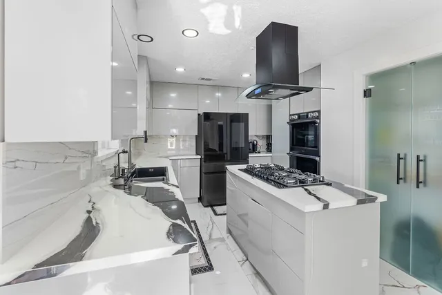 a kitchen with a stove a refrigerator and a sink