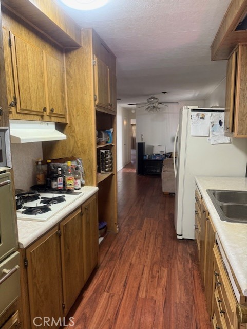 3050 West Ball Road, Unit 171 Anaheim, CA 92804 - Photo 9 of 15 a kitchen with a stove a refrigerator and a wooden cabinets