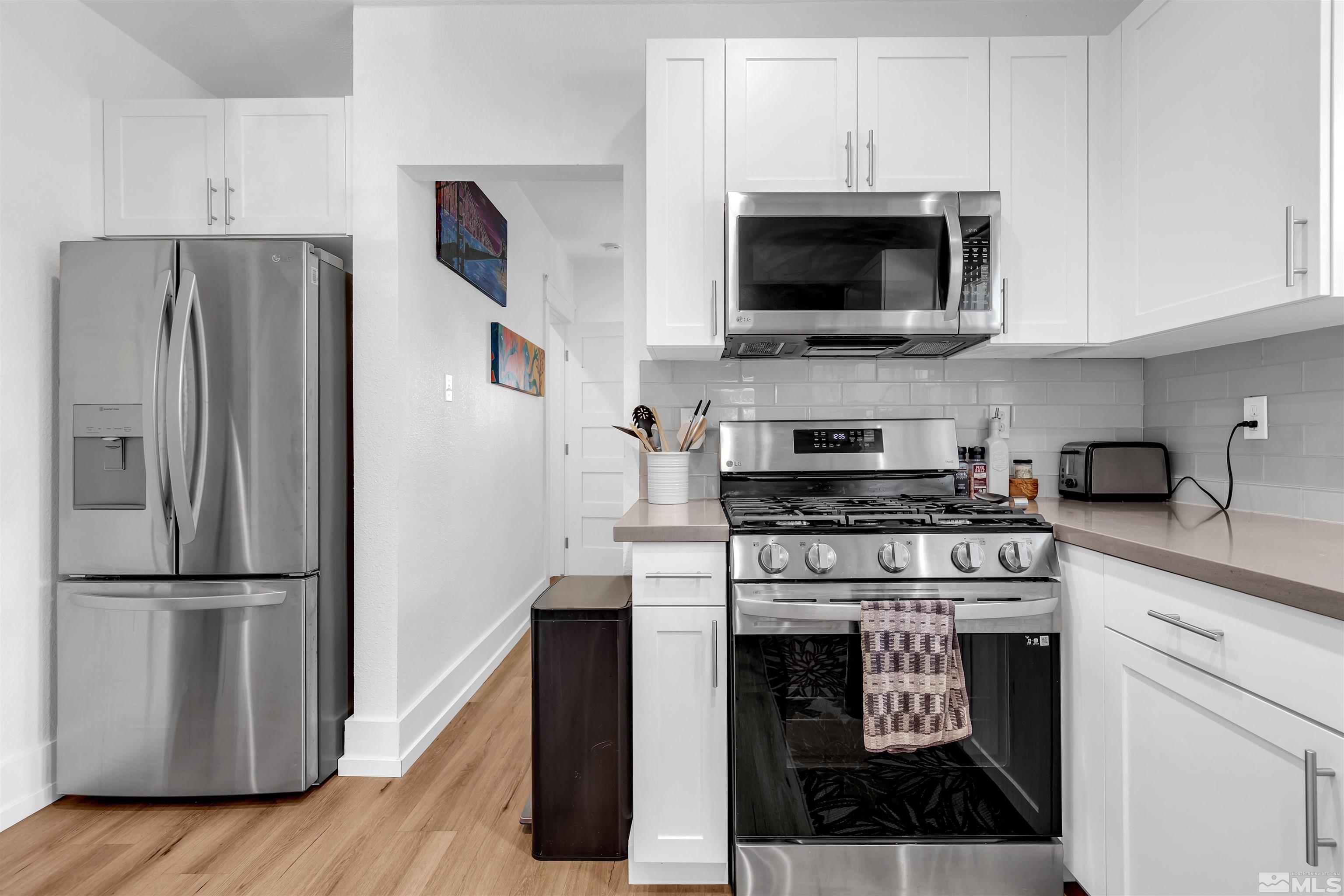 128 Stewart Street Reno, NV 89501 - Photo 10 of 24 a kitchen with stainless steel appliances granite countertop a stove a refrigerator and a microwave