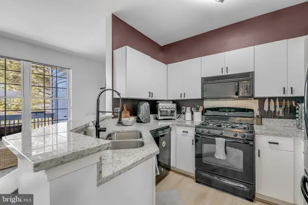 a kitchen with appliances a sink and cabinets
