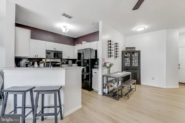 a living room with stainless steel appliances kitchen island granite countertop furniture and a refrigerator