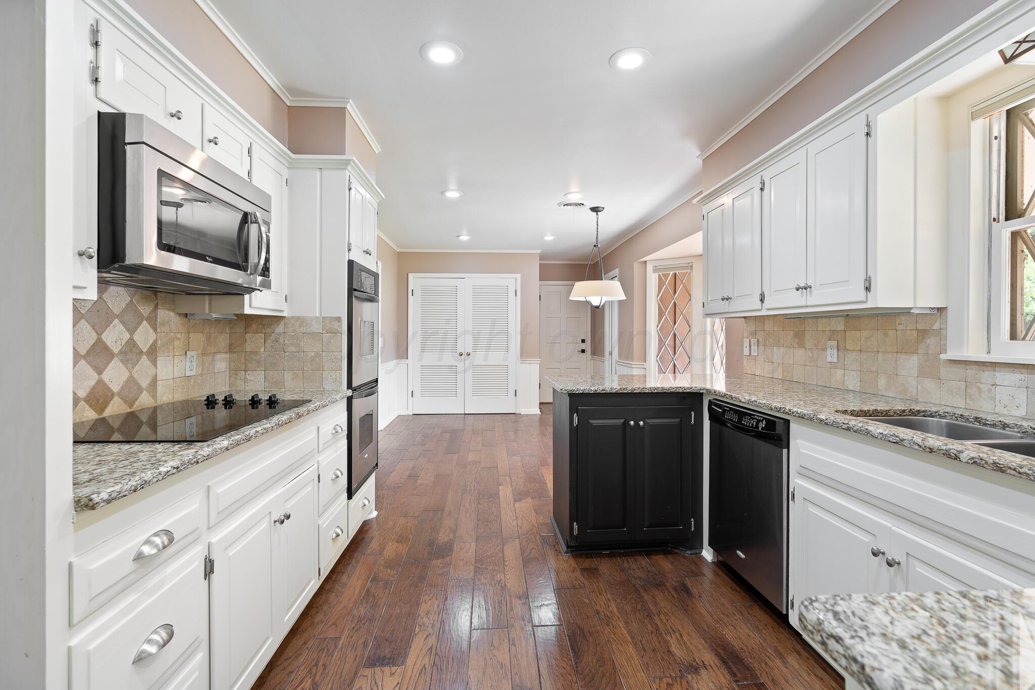3804 Doris Drive Amarillo, TX 79109 - Photo 13 of 53 a large kitchen with stainless steel appliances granite countertop a lot of counter space and wooden floor