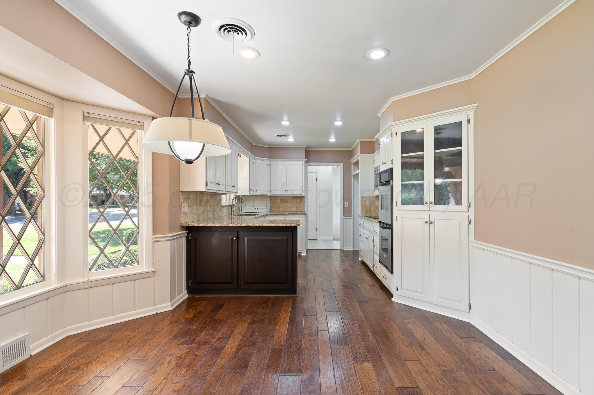3804 Doris Drive Amarillo, TX 79109 - Photo 18 of 53 a kitchen with stainless steel appliances granite countertop a refrigerator a sink dishwasher a stove and white countertops with wooden floor