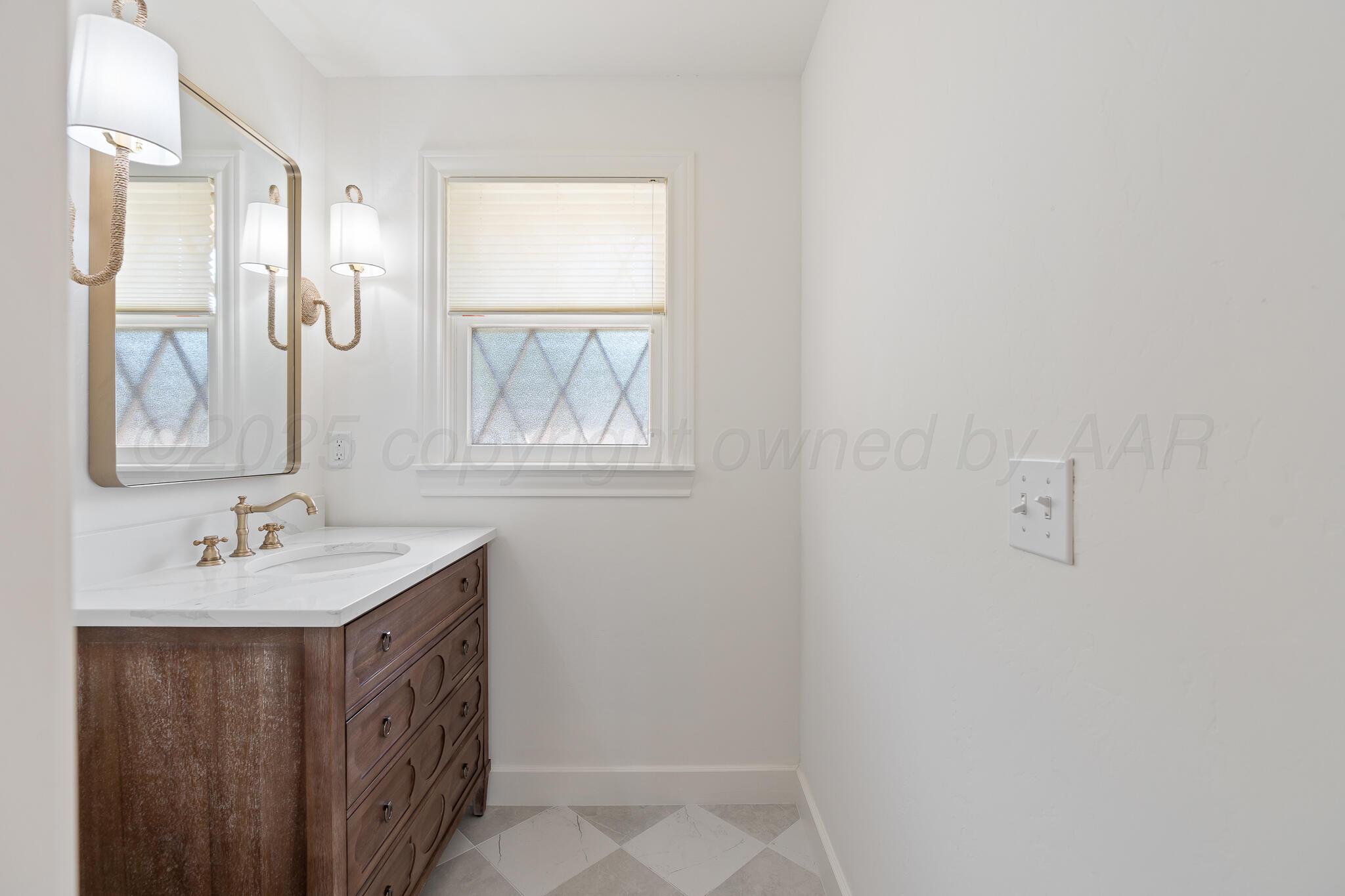 3804 Doris Drive Amarillo, TX 79109 - Photo 22 of 53 a bathroom with a sink a mirror and a window