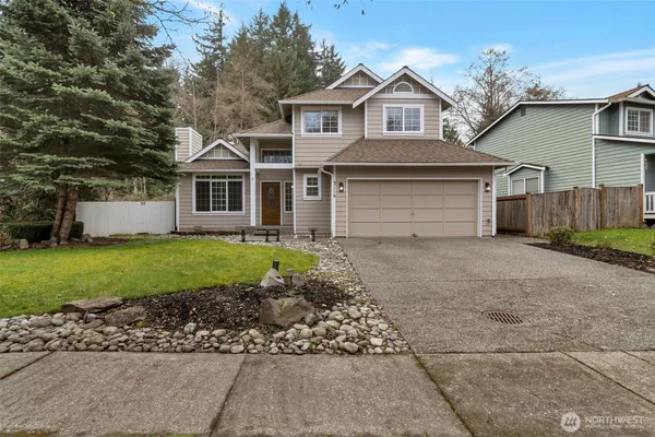 a front view of a house with a garden and yard