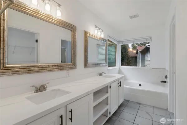 a bathroom with a tub sink and mirror