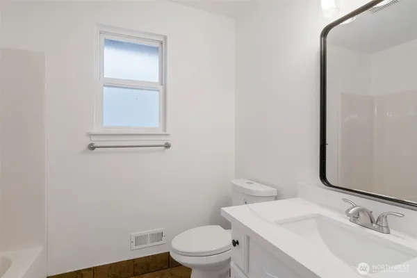 a bathroom with a sink a toilet and a mirror