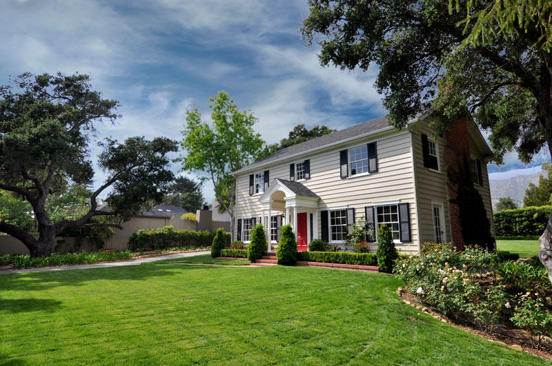 a view of an house with backyard and a tree