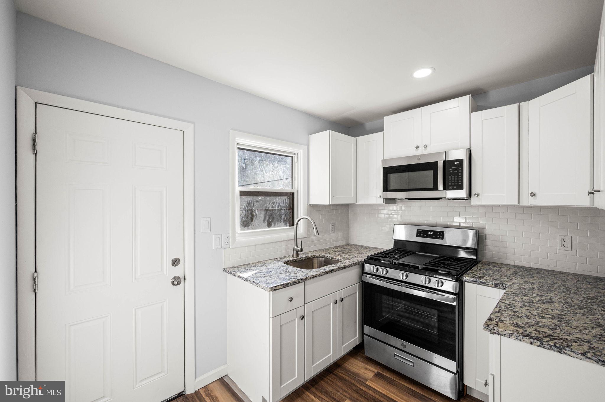 2139 North 10th Street Philadelphia, PA 19122 - Photo 11 of 20 a kitchen with stainless steel appliances granite countertop a stove a sink and a microwave