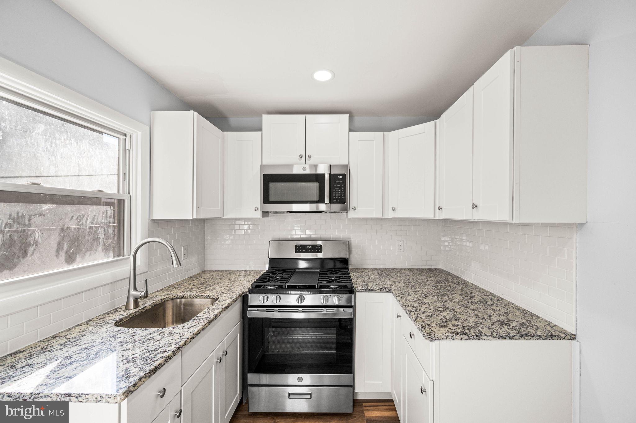 2139 North 10th Street Philadelphia, PA 19122 - Photo 12 of 20 a kitchen with granite countertop a sink stove and cabinets