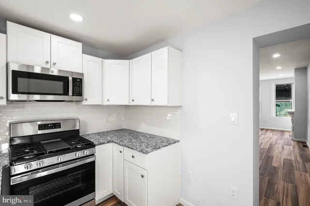 a kitchen with stainless steel appliances a stove a microwave and cabinets