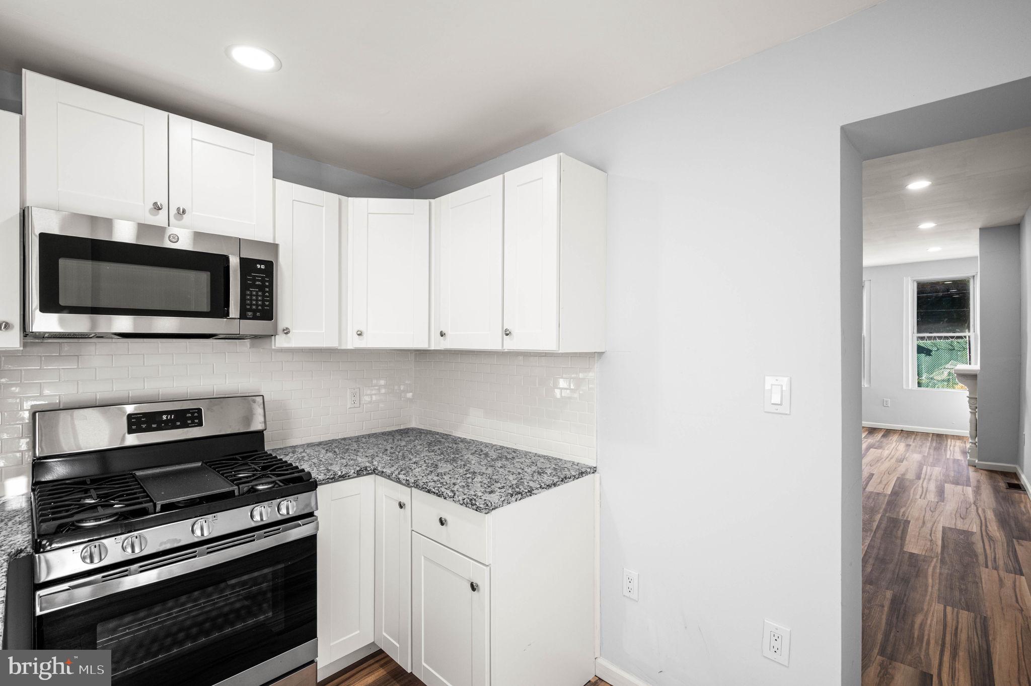 2139 North 10th Street Philadelphia, PA 19122 - Photo 13 of 20 a kitchen with stainless steel appliances a stove a microwave and cabinets