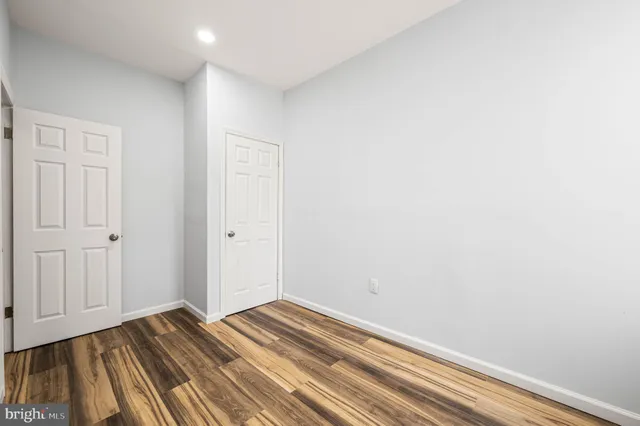 a view of a room with wooden floor and closet area