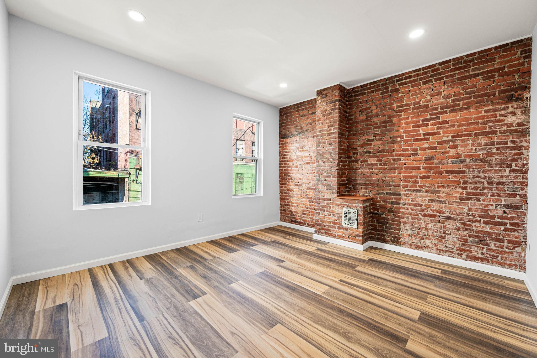 2139 North 10th Street Philadelphia, PA 19122 - Photo 17 of 20 a view of an empty room with wooden floor and a window