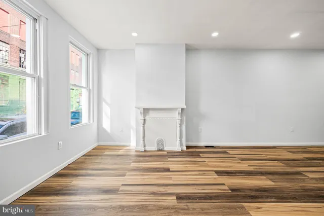 a view of a livingroom with wooden floor and a window