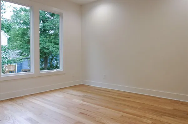 a view of a room that has wooden floor and a window