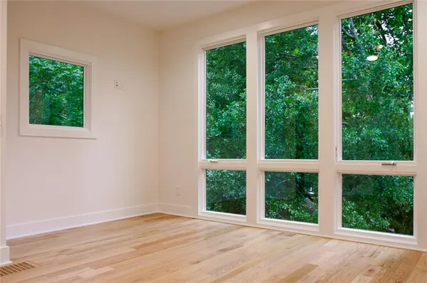 a view of an empty room with wooden floor and outdoor view